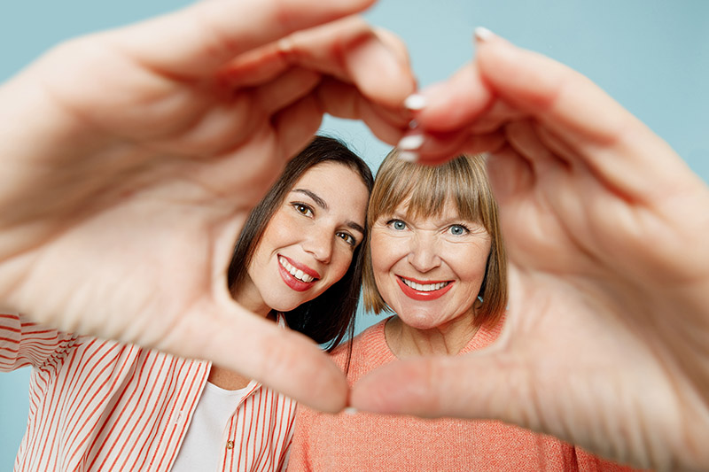 Elder parent taking photo with younger daughter